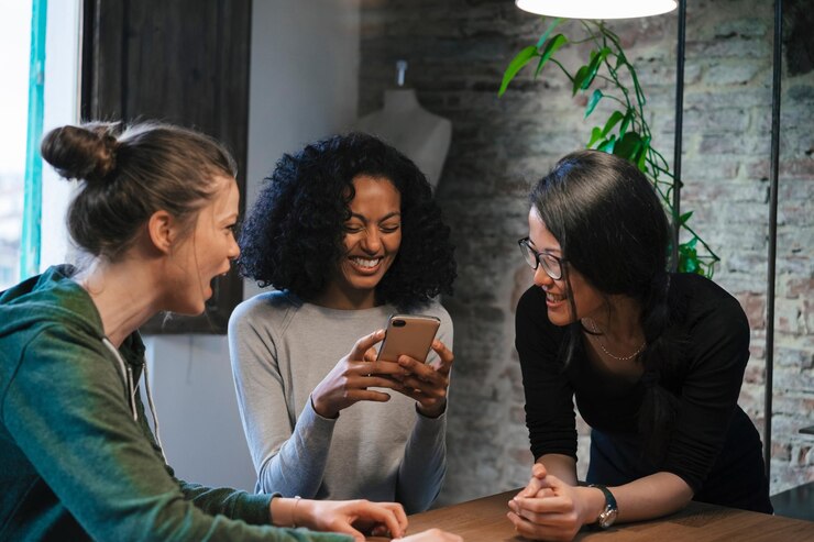 Foto amigos olhando para o telemóvel sorrindo