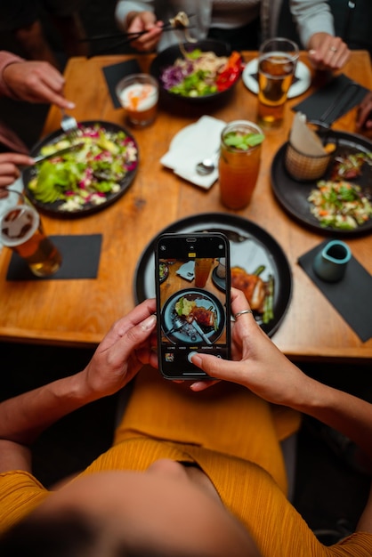 Amigos para jantar tirando fotos de comida