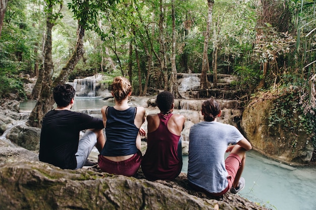Foto amigos pasando el rato junto a una cascada en la jungla