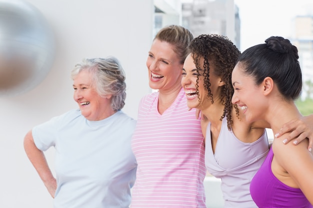 Amigos de pie brazos en estudio de fitness