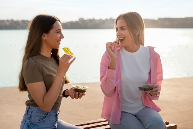 Foto amigos de plano medio comiendo bocadillos de algas