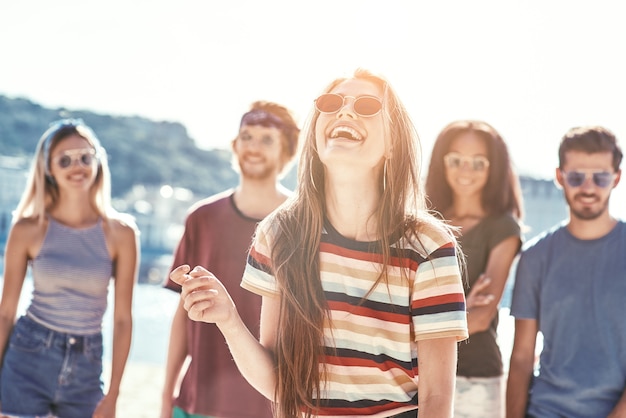 Amigos en la playa feliz grupo de jóvenes amigos se divierten y celebran mientras saltan y