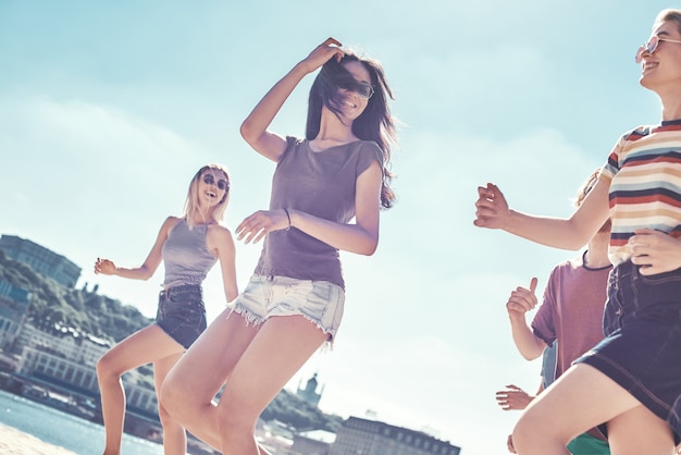 Amigos en la playa feliz grupo de jóvenes amigos se divierten y celebran mientras saltan y