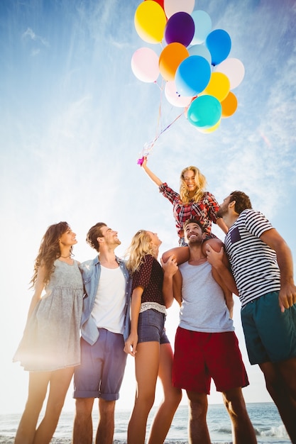 Foto amigos posando con globo sobre arena.