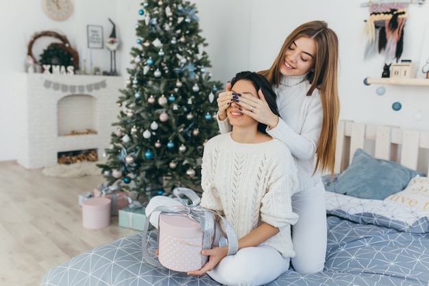 Amigos que abrem presentes de Natal.