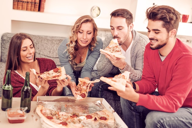 Amigos que comem a pizza