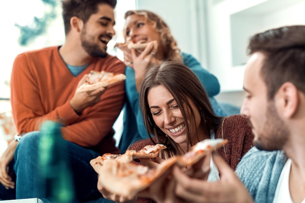 Amigos que comem a pizza