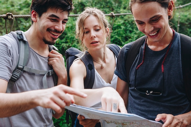 Foto amigos que encuentran su camino con un mapa.