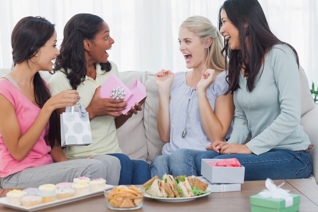 Amigos que ofrecen regalos a la mujer durante la fiesta