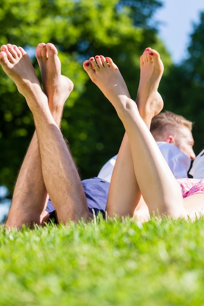 Amigos que ponen con las piernas cruzadas en el parque