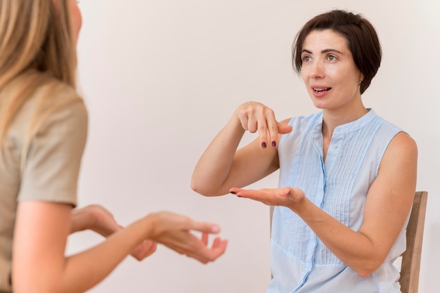 Foto amigos que usan lenguaje de señas para hablar entre ellos.