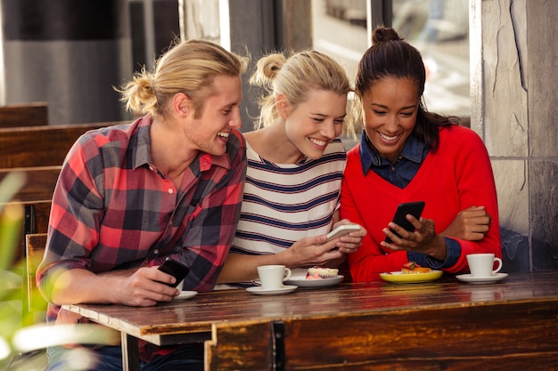 Amigos que usan teléfonos inteligentes