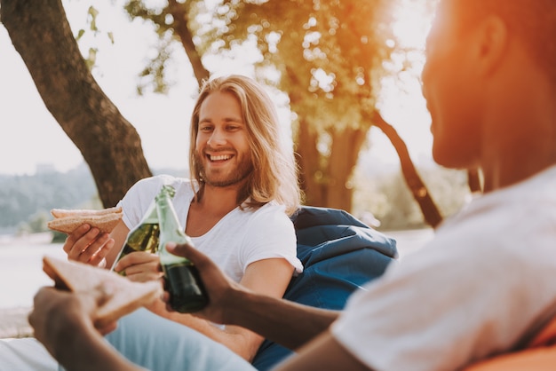 Amigos relajados almorzan en la naturaleza