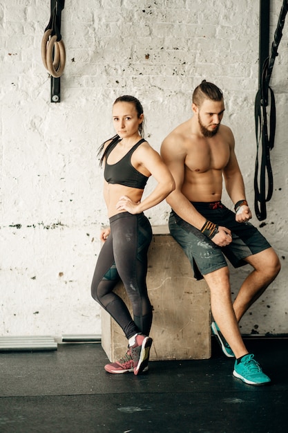 Amigos relajantes y tomando un descanso después de hacer ejercicio en un gimnasio de entrenamiento cruzado