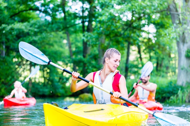 Foto amigos remando con canoa en el río del bosque