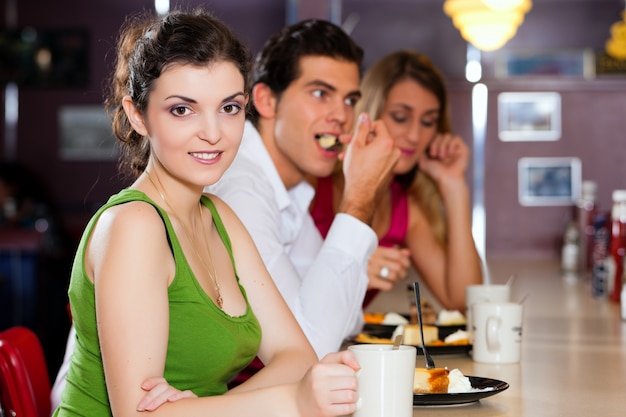 Amigos en el restaurante comiendo y bebiendo