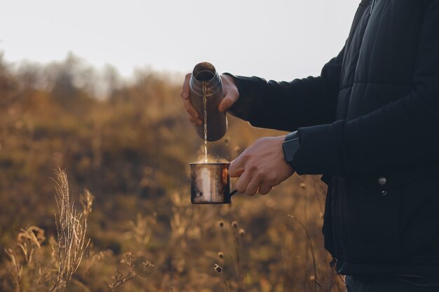 Amigos se reunieron para tomar un café Otoño con un termo caliente y vapor Clima frío Café caliente en la mano Té caliente