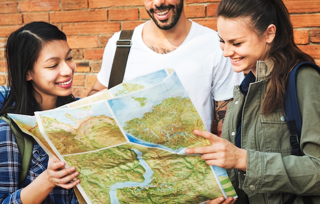 Foto amigos revisando el mapa para direcciones