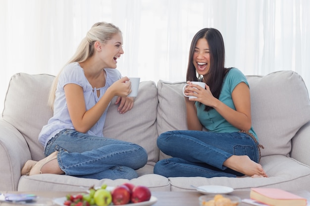 Amigos riendo y tomando café juntos