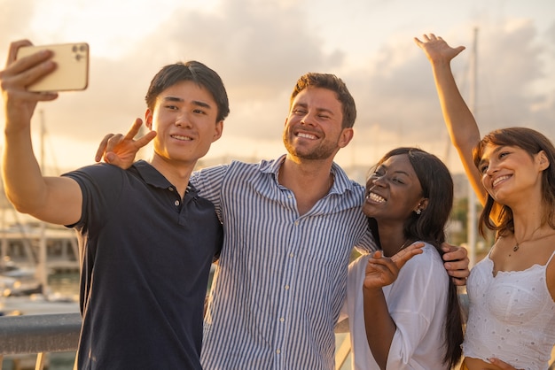 Amigos rindo tirando selfie na praia