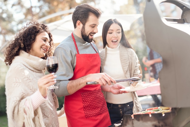 Amigos se divertem, cozinham comida, bebem álcool.