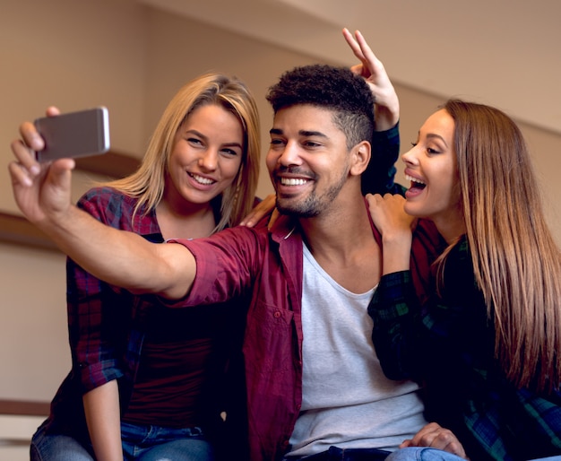 Foto amigos se divertindo, bebendo cerveja, tomando selfie.