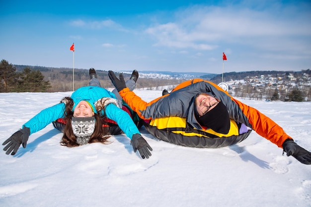 Amigos se divertindo com atividade de inverno de tubos de neve