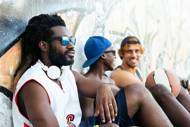 Amigos se divertindo durante um descanso depois de um jogo de basquete de rua.