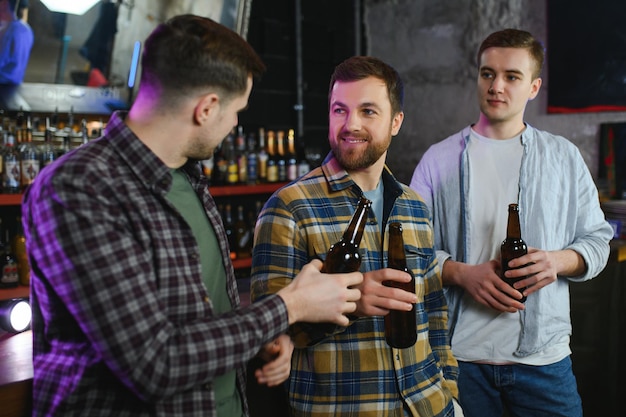 Amigos se divertindo Jovens felizes em roupas casuais bebendo cerveja no pub