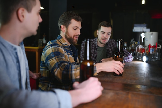 Amigos se divertindo Jovens felizes em roupas casuais bebendo cerveja no pub