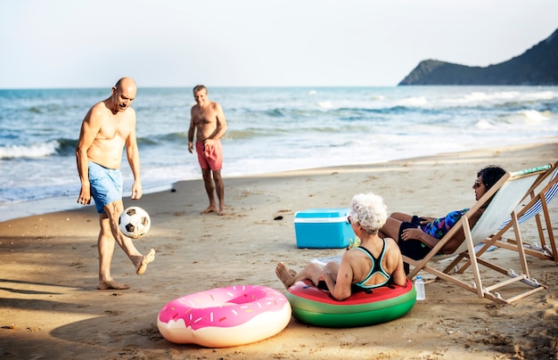 Amigos seniors disfrutando de la playa en el verano