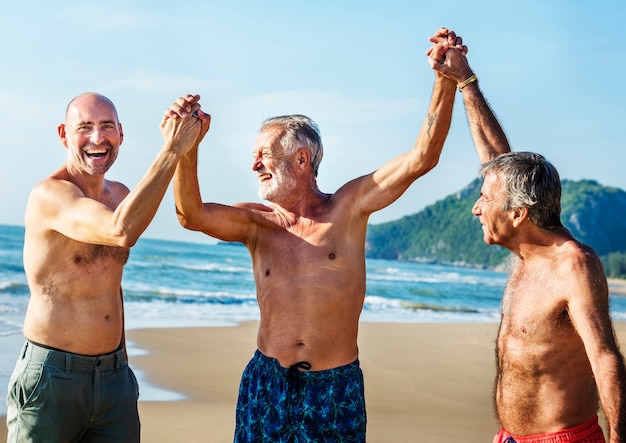 Amigos seniors disfrutando de la playa en el verano