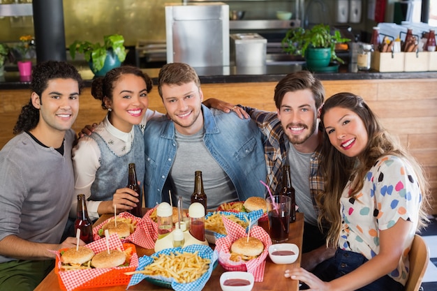 Amigos sentado por comida e bebida serviram na mesa no restaurante