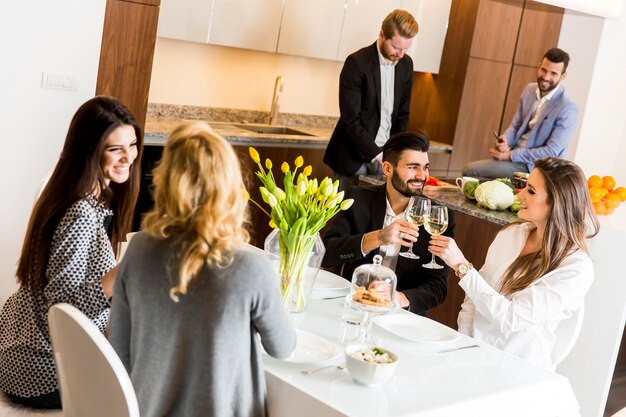 Amigos, sentados em uma mesa de jantar comemorando