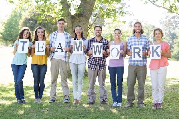 Amigos con signos de trabajo en equipo en el parque