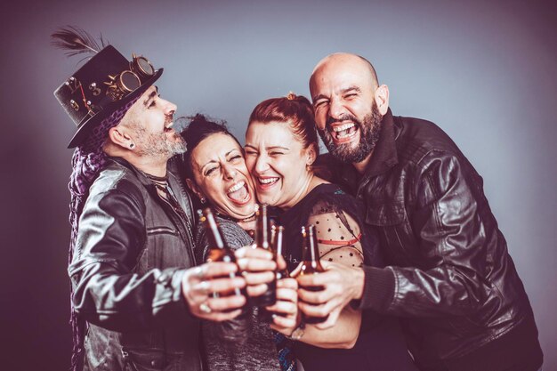 Los amigos sonríen junto con la cerveza en la mano en una foto de estudio