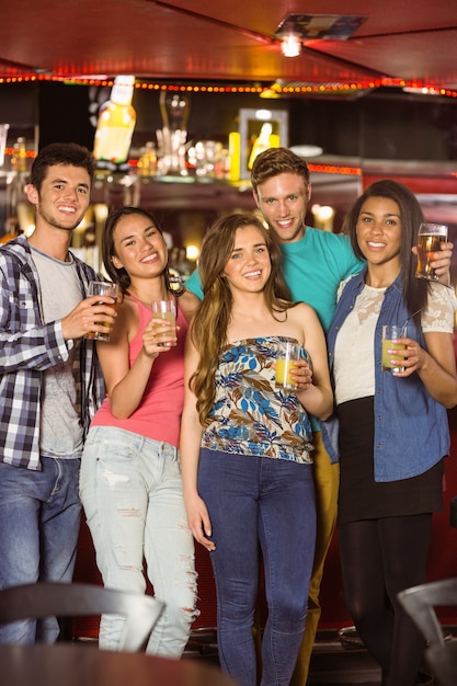 Amigos sonrientes bebiendo cerveza y bebida mixta