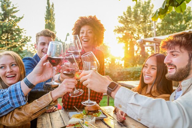 Foto amigos sonrientes brindando por las bebidas en la mesa.