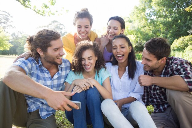 Foto amigos sonrientes en el parque tomando selfie