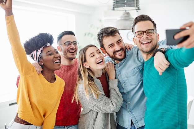 Foto amigos sonrientes posando para selfies en casa