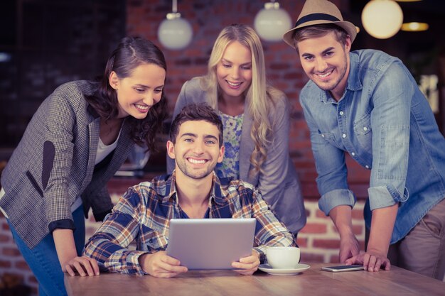 Amigos sonrientes que miran la tableta