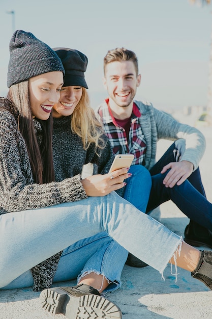 Foto amigos sonrientes sentados fuera