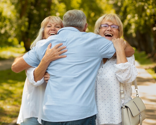 Amigos sonrientes de tiro medio abrazándose