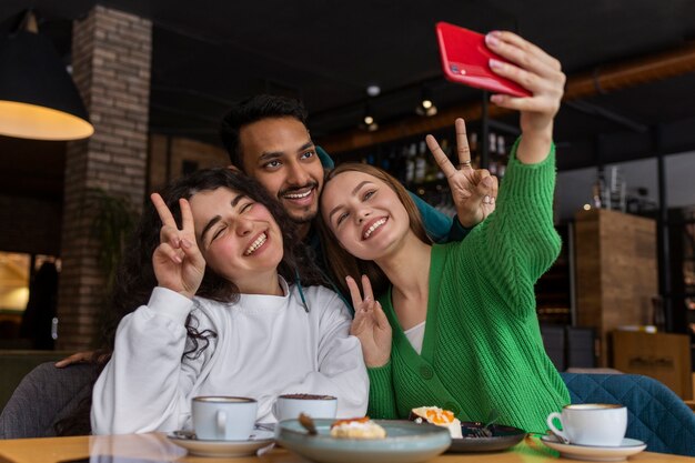 Foto amigos sonrientes de tiro medio con smartphone