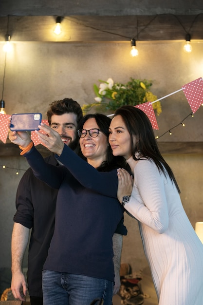 Amigos sonrientes de tiro medio tomando selfie