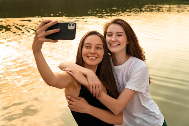 Foto amigos sonrientes de tiro medio tomando selfie