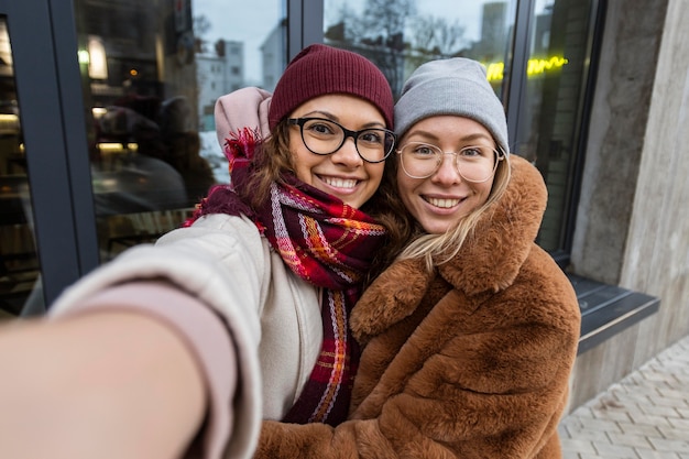 Foto amigos sonrientes de tiro medio tomando selfies