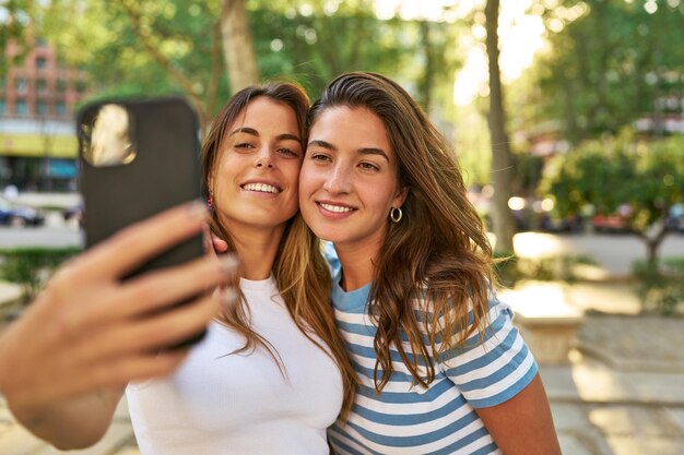 Foto amigos sonrientes tomándose un selfie en el parque