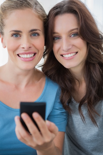 Amigos sorridentes com telefone celular