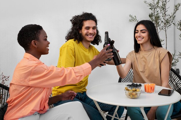 Amigos sorridentes de tiro médio com garrafas